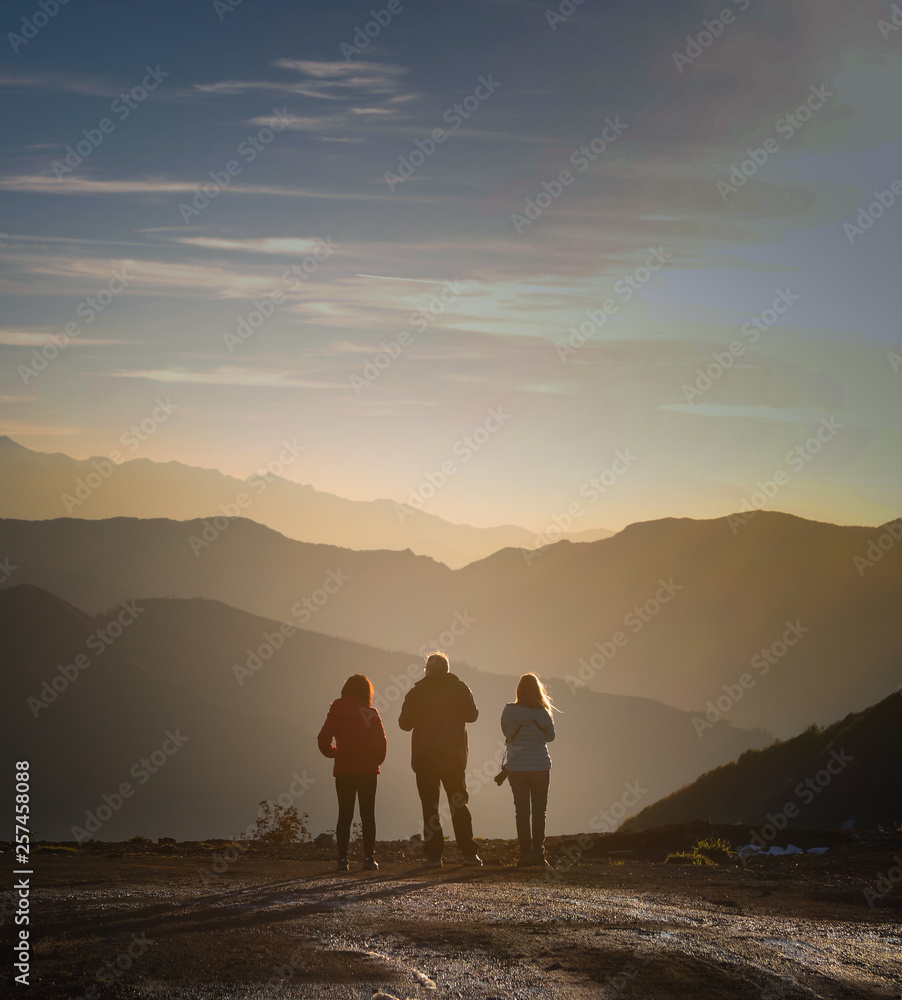 3 friends watching the sunset on mountain top