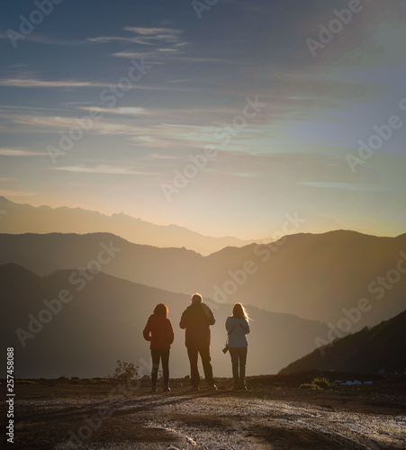 Fotografie 3 friends watching the sunset on mountain top