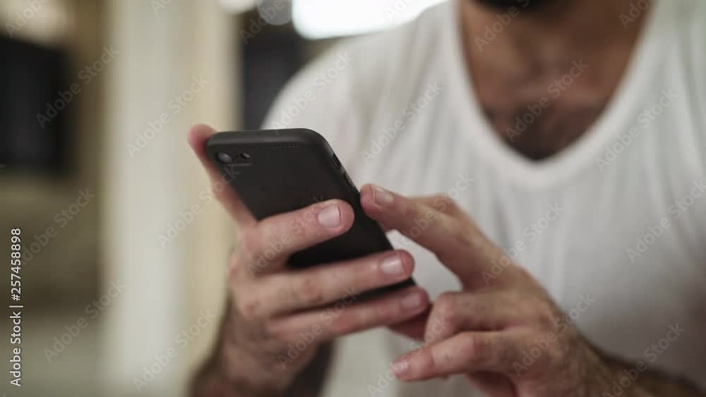 Man texting on his black phone Man texting on his black phone