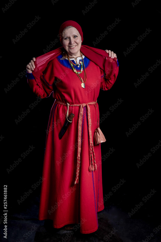 mature woman in a red dress and Viking era headgear smiling