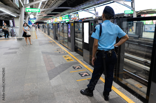 BTS skytrain guard standing at platform in Bangkok, Thailand.