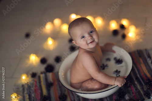 Baby bathed in milk in an iron basin with cones