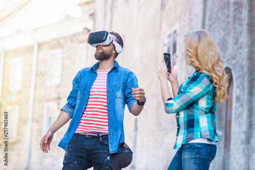 Couple walking in the street in augmented reality headset. Virtual reality and futuristic technology concept.
