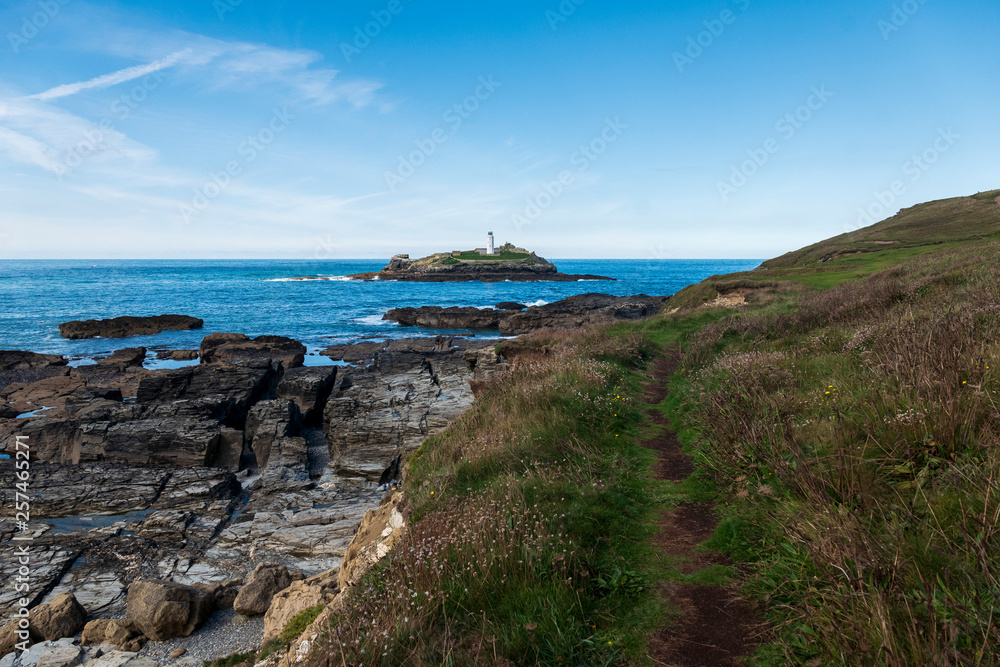 Coastal pathway with lighthouse on the background, Godrevy beach, Cornwall