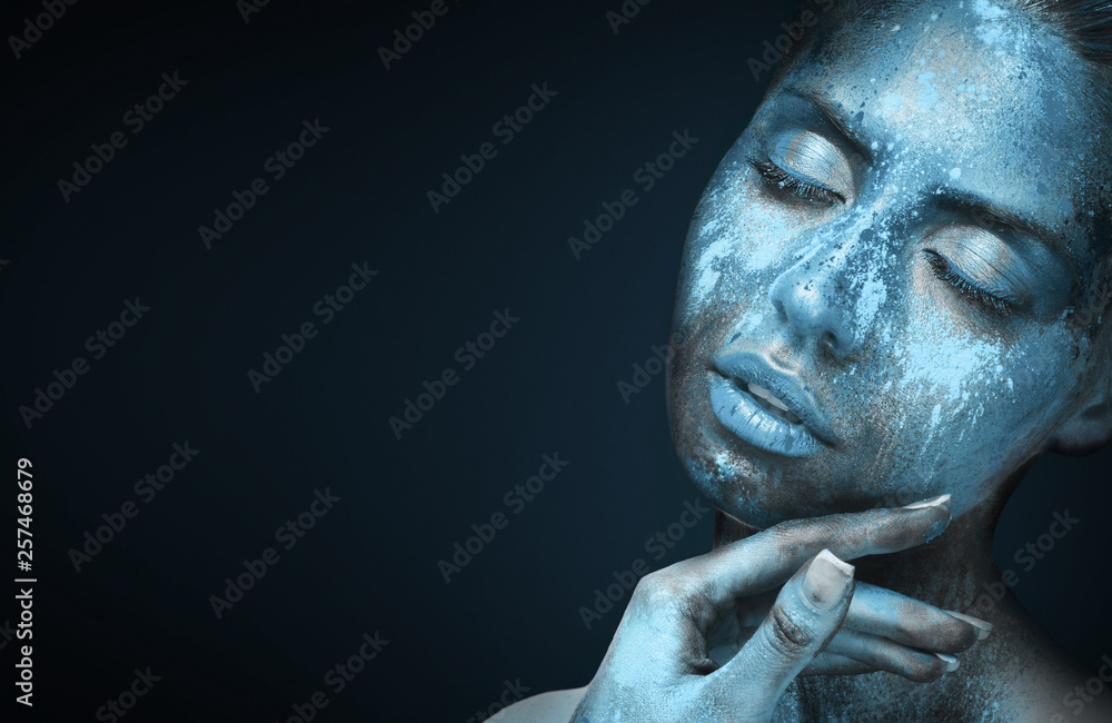 Beauty portrait of young woman with blue artistic makeup