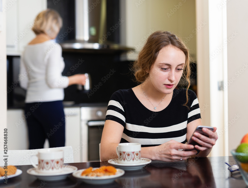 Woman with phone at kitchen