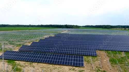 Aerial View. Flying over the solar power plant with sun. Solar panels and sun. Aerial drone shot. Construction of a plant