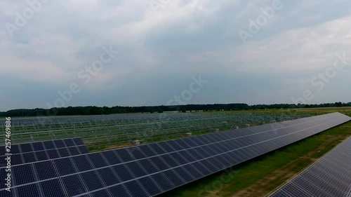 Aerial View. Flying over the solar power plant with sun. Solar panels and sun. Aerial drone shot. Construction of a plant