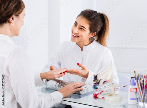 Young smiling woman doing manicure