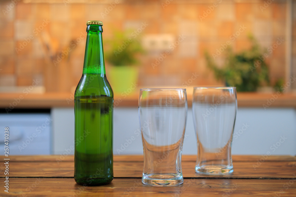 Bottle with beer and empty glasses on the table Bottle with beer and empty glasses on the table