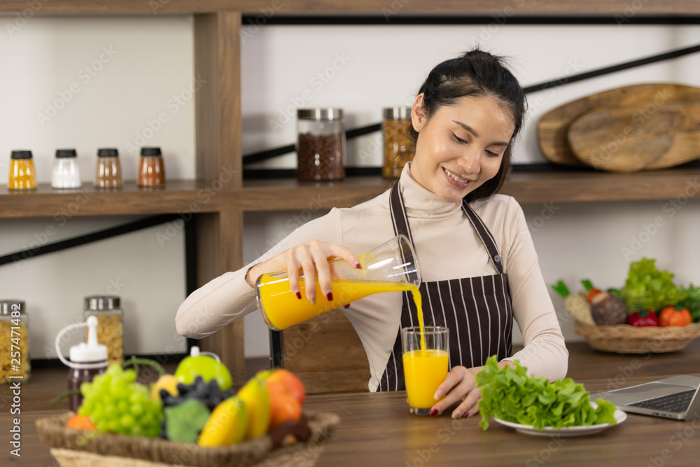 Young woman cooking a hamburger in kitchen with a smile and delicious Young woman cooking a hamburger in kitchen with a smile and delicious