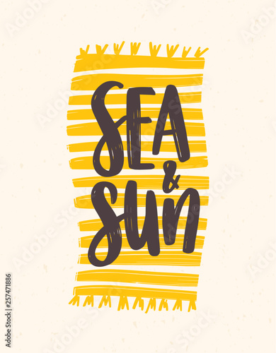 Sea And Sun slogan handwritten with elegant cursive font on beach towel or blanket