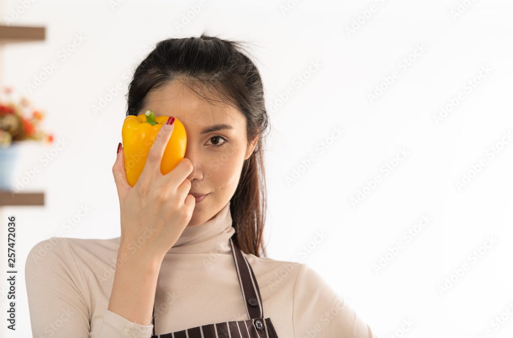 Young woman cooking a hamburger in kitchen with a smile and delicious Young woman cooking a hamburger in kitchen with a smile and delicious