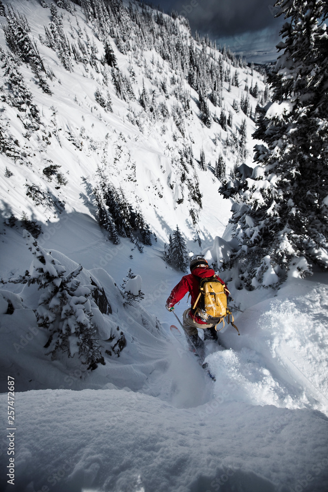 A telemark skier jumping into a narrow chute in Bridger Bowl, Montana. A telemark skier jumping into a narrow chute in Bridger Bowl, Montana.