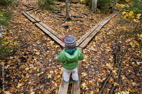 A young girl walks across hiking bridges in Grafton Notch State Park, Maine. photo