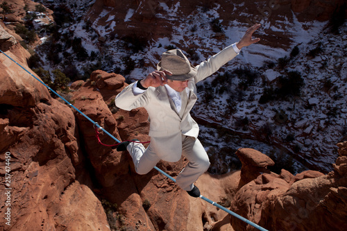 Male highliner in white pinned stripe suite, Moab, Utah, USA. photo