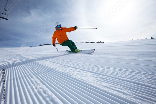 A male alpine skier smiles while skiing untracked groomers in Vail, Colorado. photo