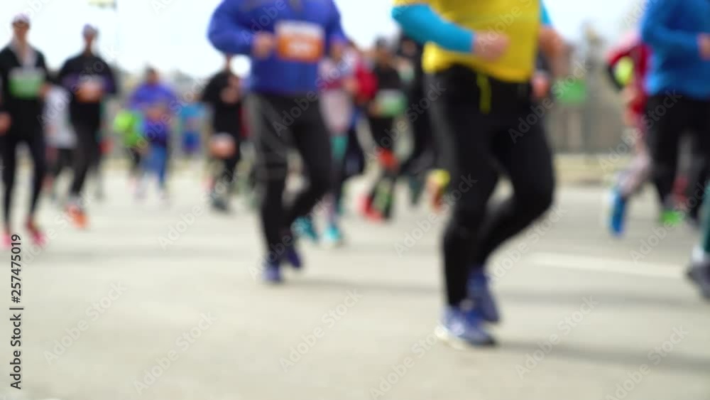 blurred colorful crowd of people running at city marathon on asphalt road blurred colorful crowd of people running at city marathon on asphalt road