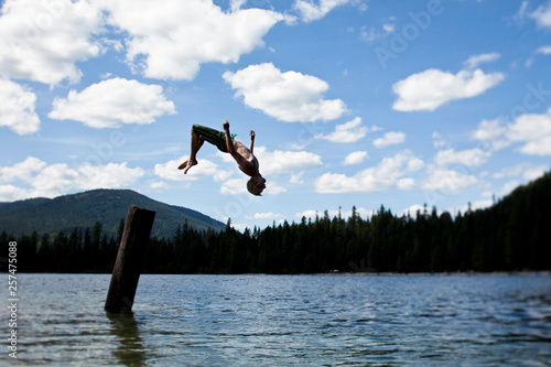 A young man backflipping off a pier at Priest Lake, Idaho. photo