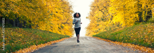 Bilde på lerret Woman jogging on country road in Autumn