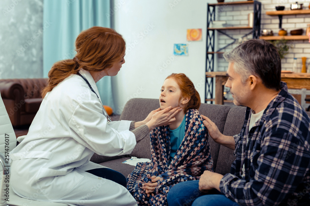 Nice professional doctor touching her patients neck Nice professional doctor touching her patients neck