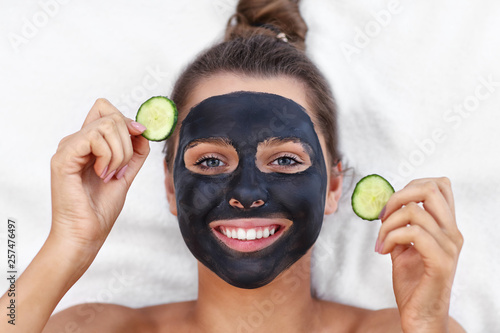 Happy woman having facial in spa salon