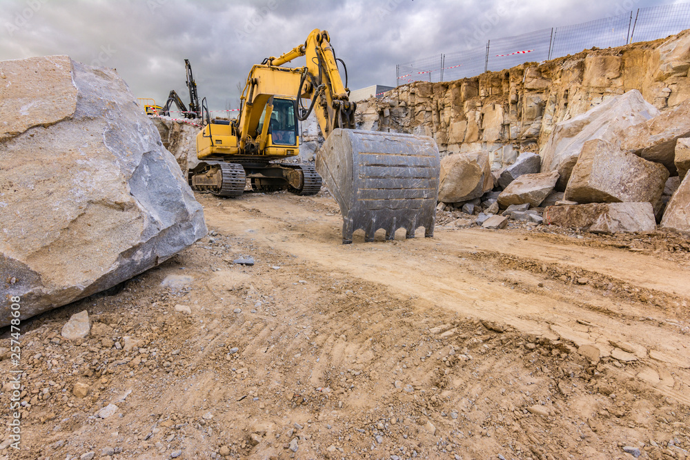 Obraz premium Excavator in a work extracting granite to transform into gravel
