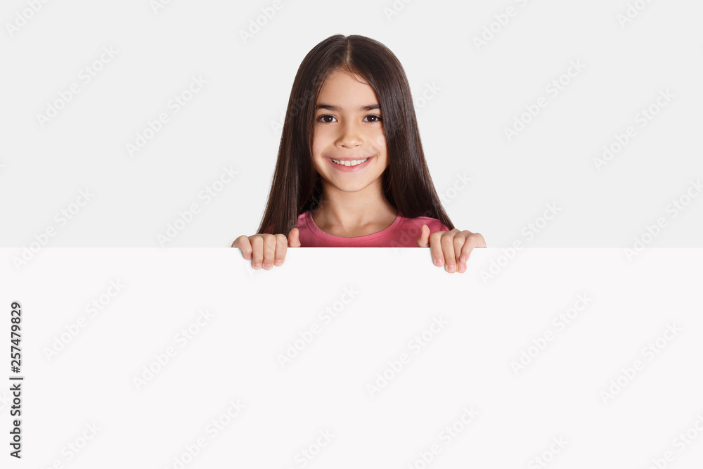 Schoolgirl with white empty banner for your advertisement Schoolgirl with white empty banner for your advertisement