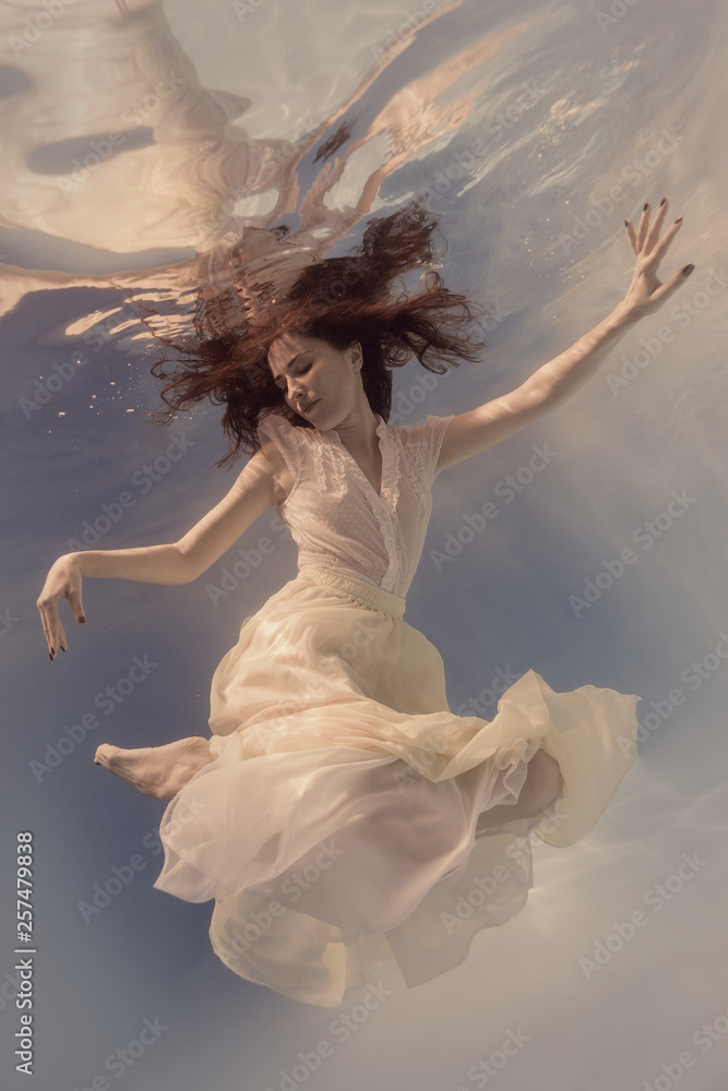 Naklejka premium Girl in dress under water