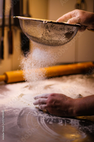 The chef mixes the dough from flour and eggs. Smoke flour Sifting flour. Chef's hands. Kitchen processes