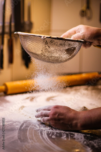 The chef mixes the dough from flour and eggs. Smoke flour Sifting flour. Chef's hands. Kitchen processes