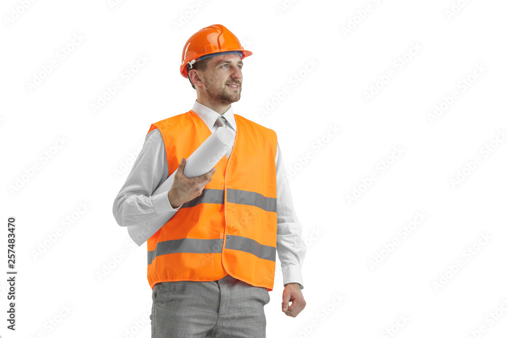 The builder in a construction vest and orange helmet standing on white studio background. Safety specialist, engineer, industry, architecture, manager, occupation, businessman, job concept The builder in a construction vest and orange helmet standing on white studio background. Safety specialist, engineer, industry, architecture, manager, occupation, businessman, job concept