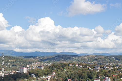Panorama of the city by the mountains in summer © nellino7