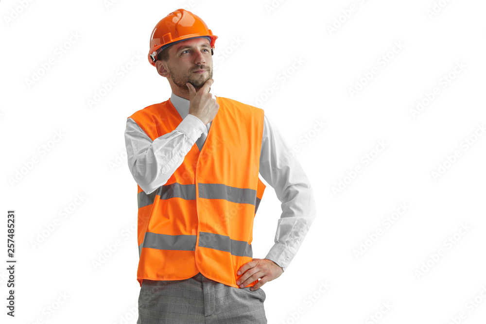The builder in a construction vest and orange helmet standing on white studio background. Safety specialist, engineer, industry, architecture, manager, occupation, businessman, job concept The builder in a construction vest and orange helmet standing on white studio background. Safety specialist, engineer, industry, architecture, manager, occupation, businessman, job concept