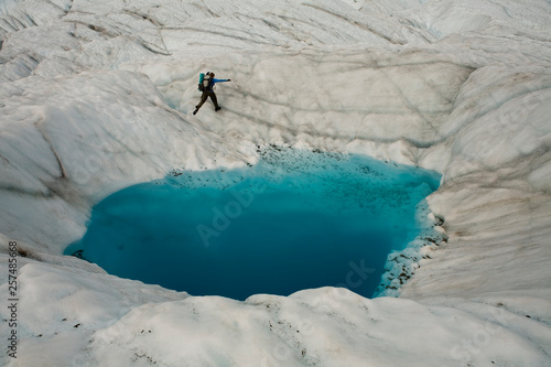 Person on glacier hiking past a  blue pool, McCarthy, Alaska. photo