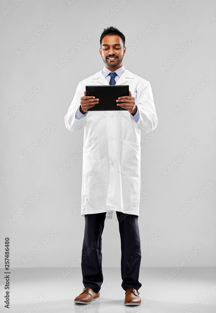 medicine, science and profession concept - smiling indian male doctor or scientist in white coat with tablet computer over grey background