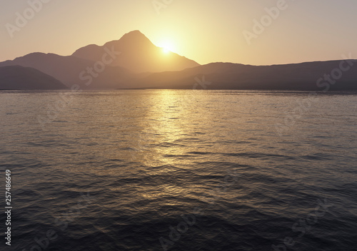 sun setting over calm mountain lake morning mood