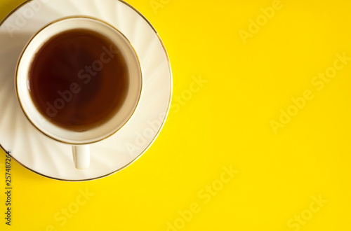 Top view image of a Cup of tea on a yellow background. Apartment lay in. Copy space