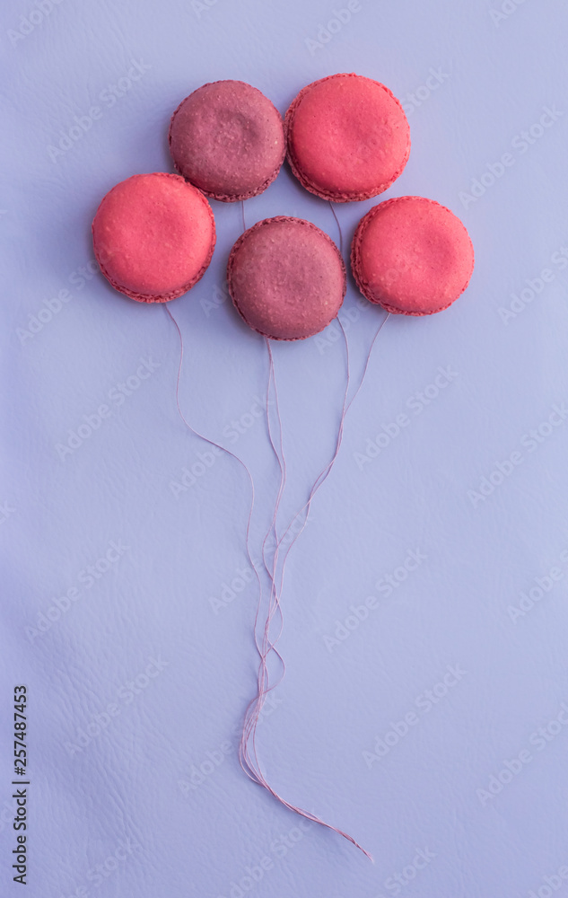 creative five pink almond cookies in the form of balloons on a lilac background creative five pink almond cookies in the form of balloons on a lilac background