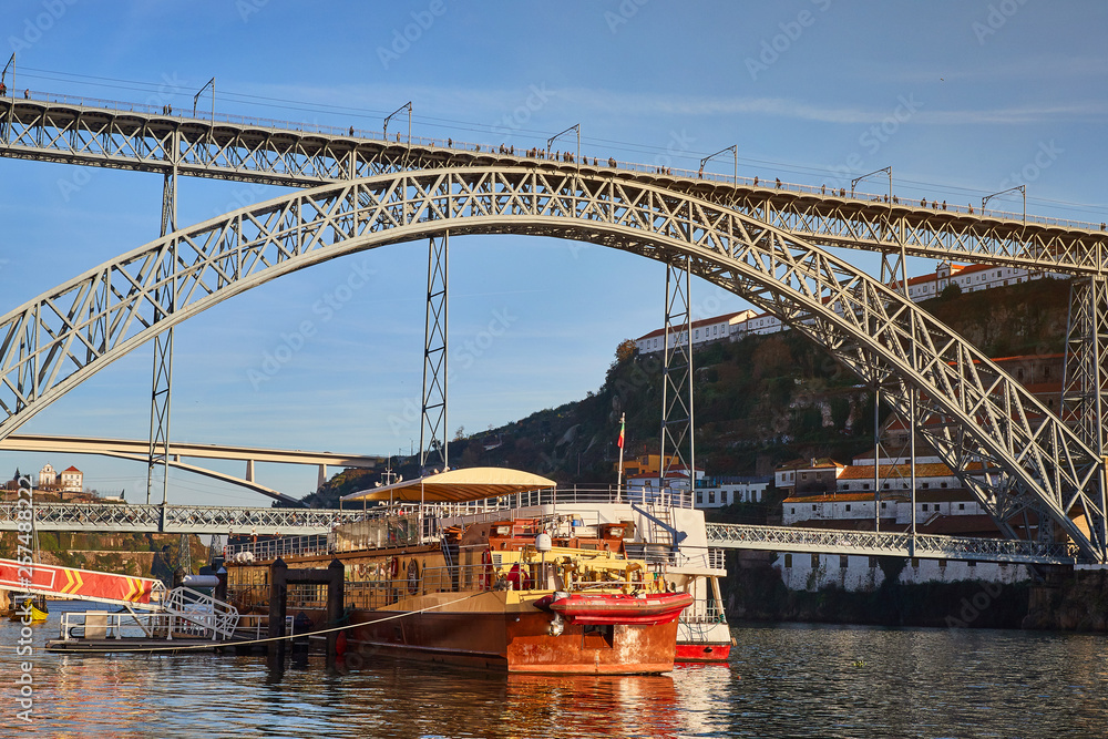 View of the historic city of Porto, Portugal with the Dom Luiz bridge. A metro train can be seen on the bridge