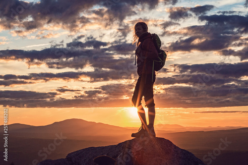 Silhouette of female hiker at summit of Borestone Mountain at sunset, Maine, USA