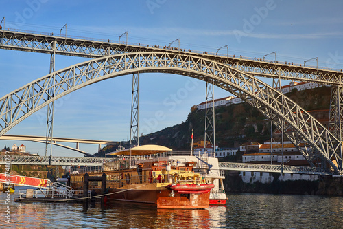 View of the historic city of Porto, Portugal with the Dom Luiz bridge. A metro train can be seen on the bridge © bondvit