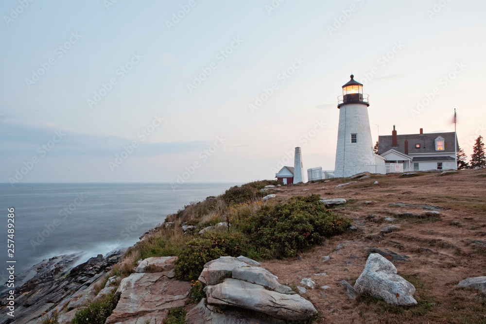 A Maine lighthouse stands guard at the edge of the ocean. A Maine lighthouse stands guard at the edge of the ocean.