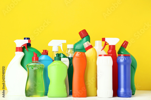 Bottles with detergent on yellow background