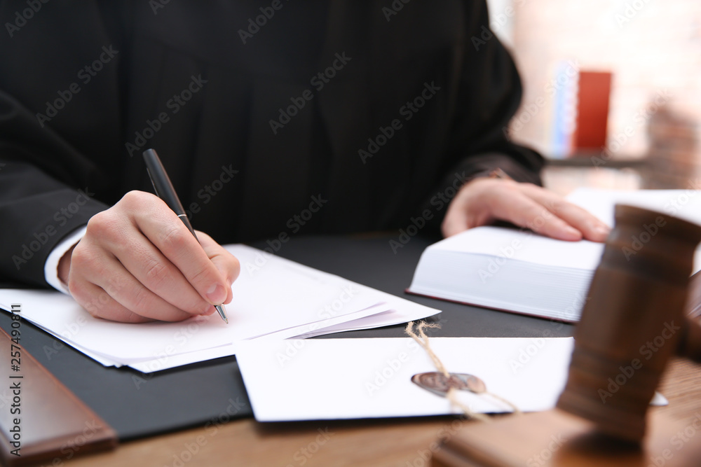 Obraz premium Judge working with papers at table in office, closeup. Law and justice concept