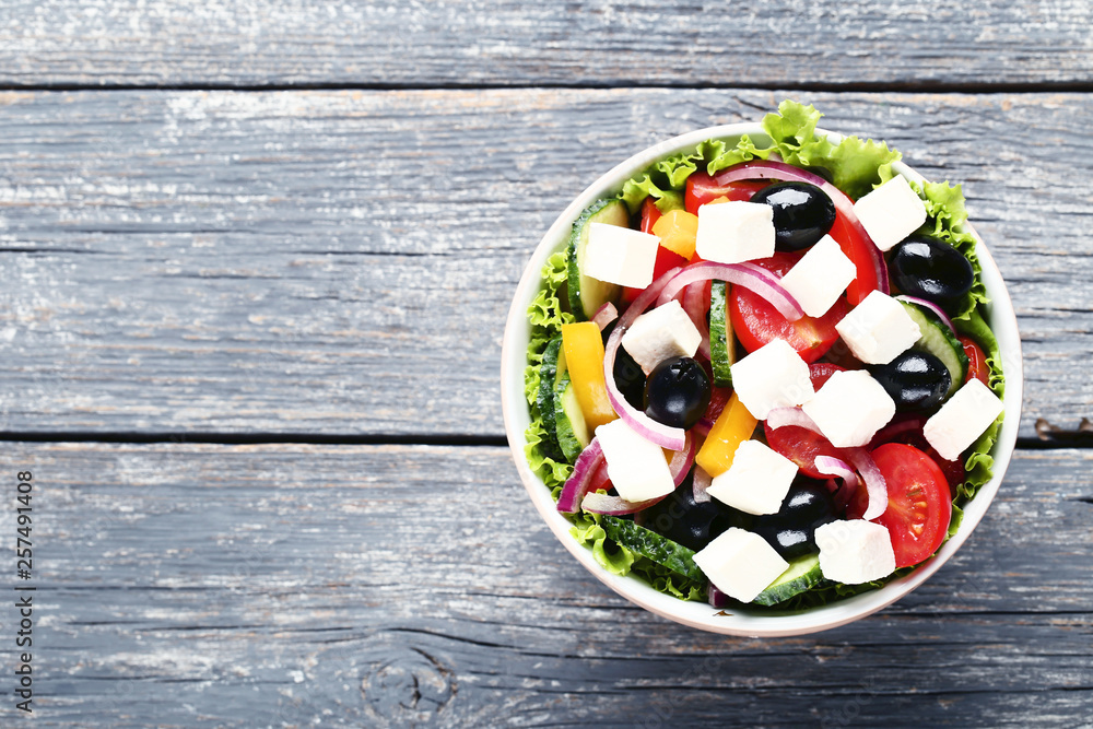 Vegetable salad in bowl on grey wooden table Vegetable salad in bowl on grey wooden table