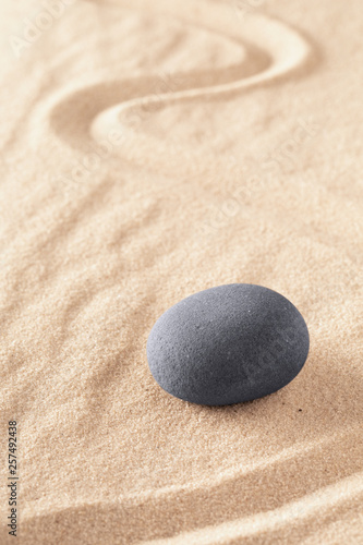 Zen stone Japanese sand garden round rock in sand. Buddhism or yoga background for spiritual purity and concentration.