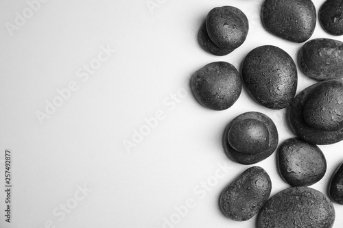 Wet zen stones on white background, top view with space for text