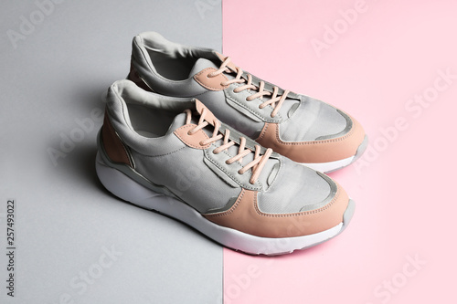 Pair of sports shoes on color background