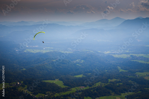 Paraglider above mountain valley of Begunje and Radovljica, after taking off from Dobrca mountain, Upper Carniola, Slovenia photo